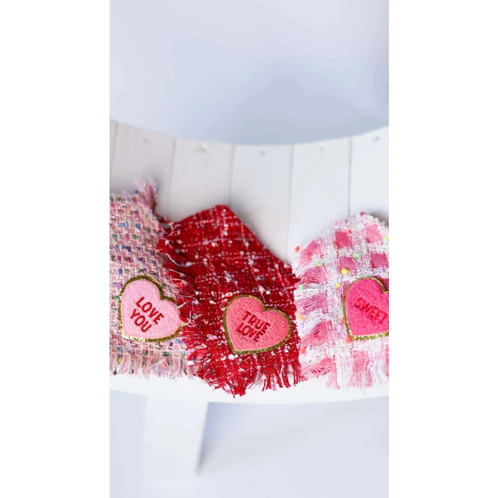 Three heart-shaped fabric patches with true love coco embroidered messages on red tweed chusta true love fabrics