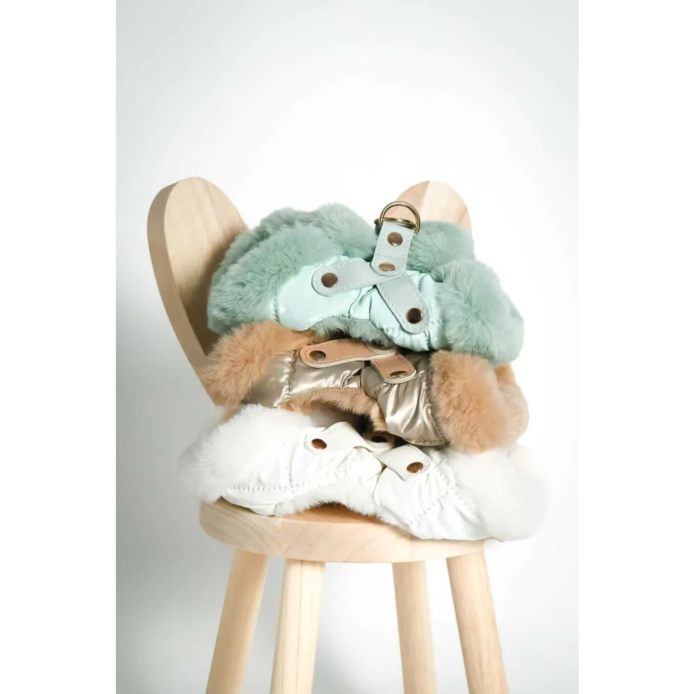 Stacked fluffy faux-fur-lined szelki bezuciskowe coats in mint green gold and white with okucia pokryte 24k złotem